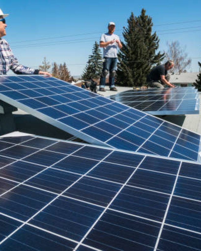 Workers installing solar panels on a residential homes roof.